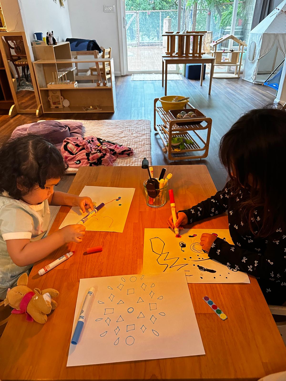 Children drawing with markers at the art table